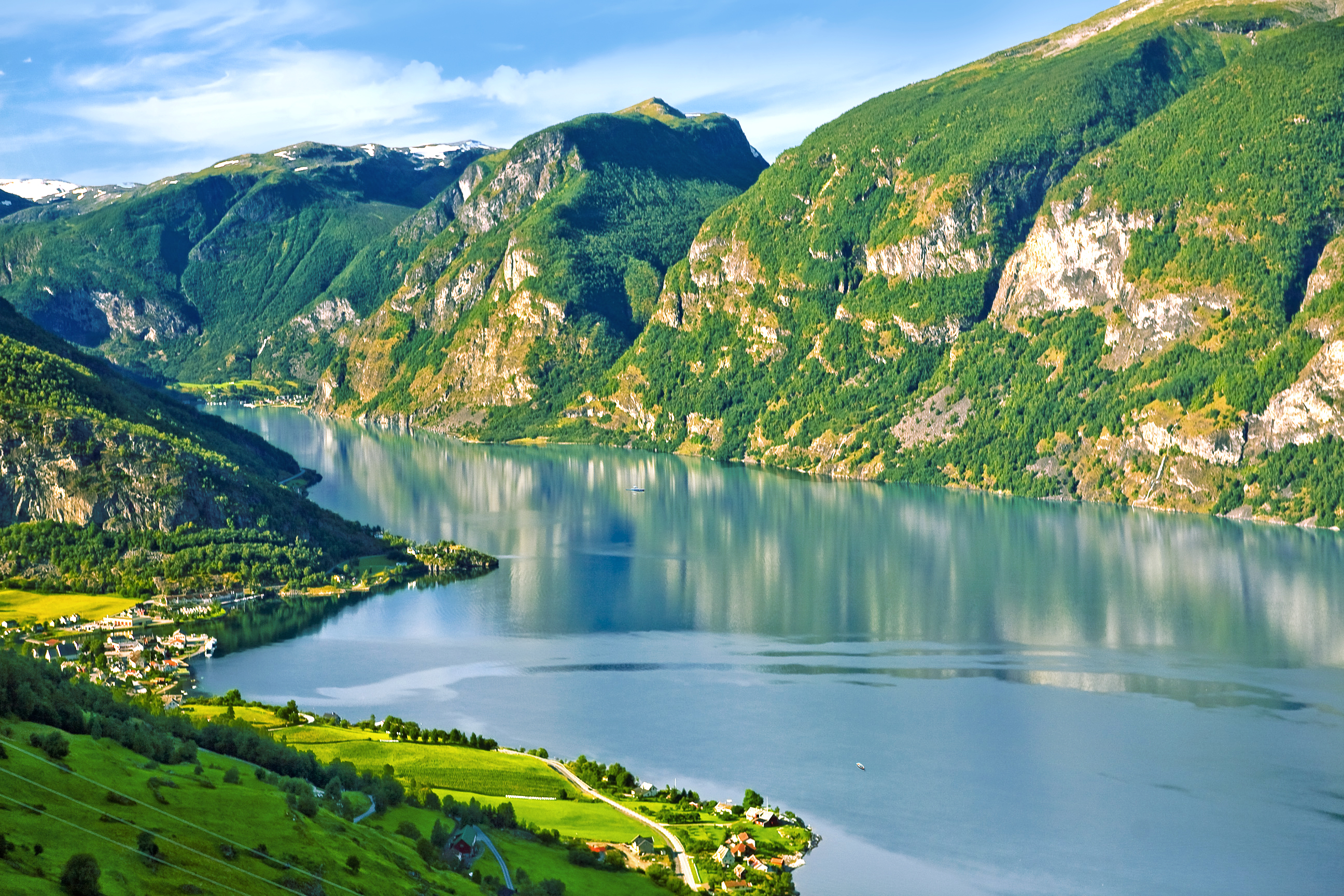 A blue river going diagonally across the picture, with lush green mountains flanking it. 