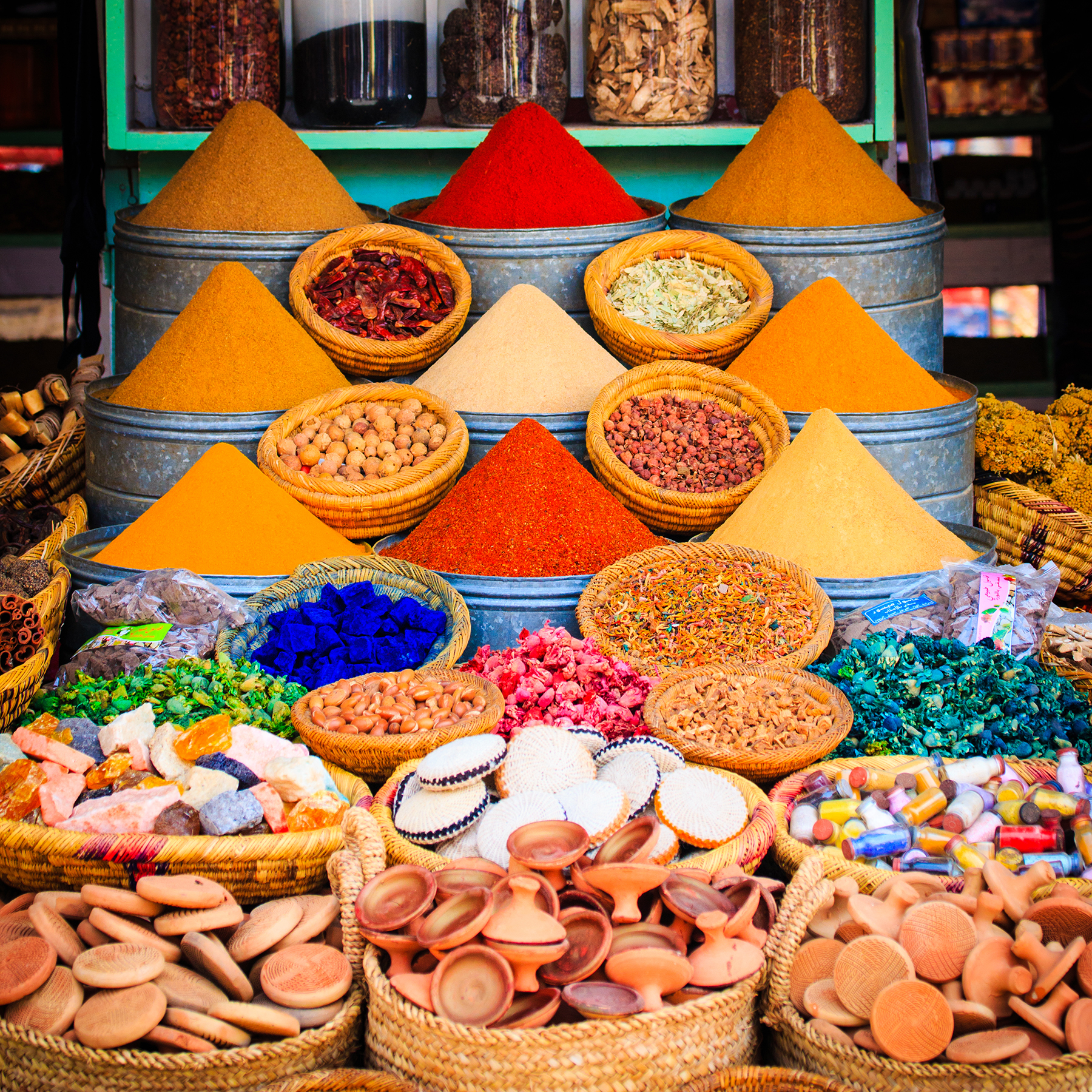 Spice market in Marrakesh, brightly colored different spices in different containers.
