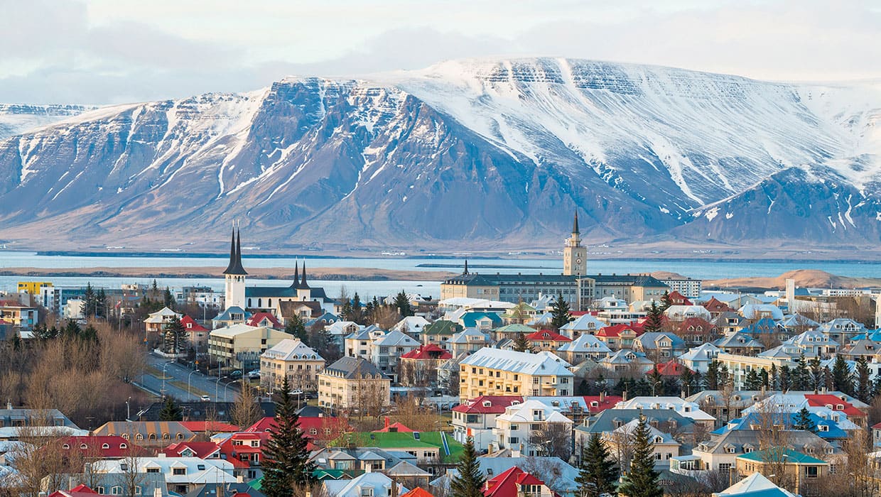 Small town with mountains in background covered in snow