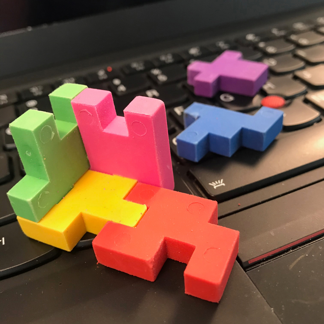 Photo of puzzle pieces on top of a laptop keyboard